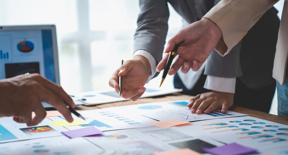 Homme âgé aux cheveux blancs clairsemés, souriant légèrement, portant une chemise blanche boutonnée