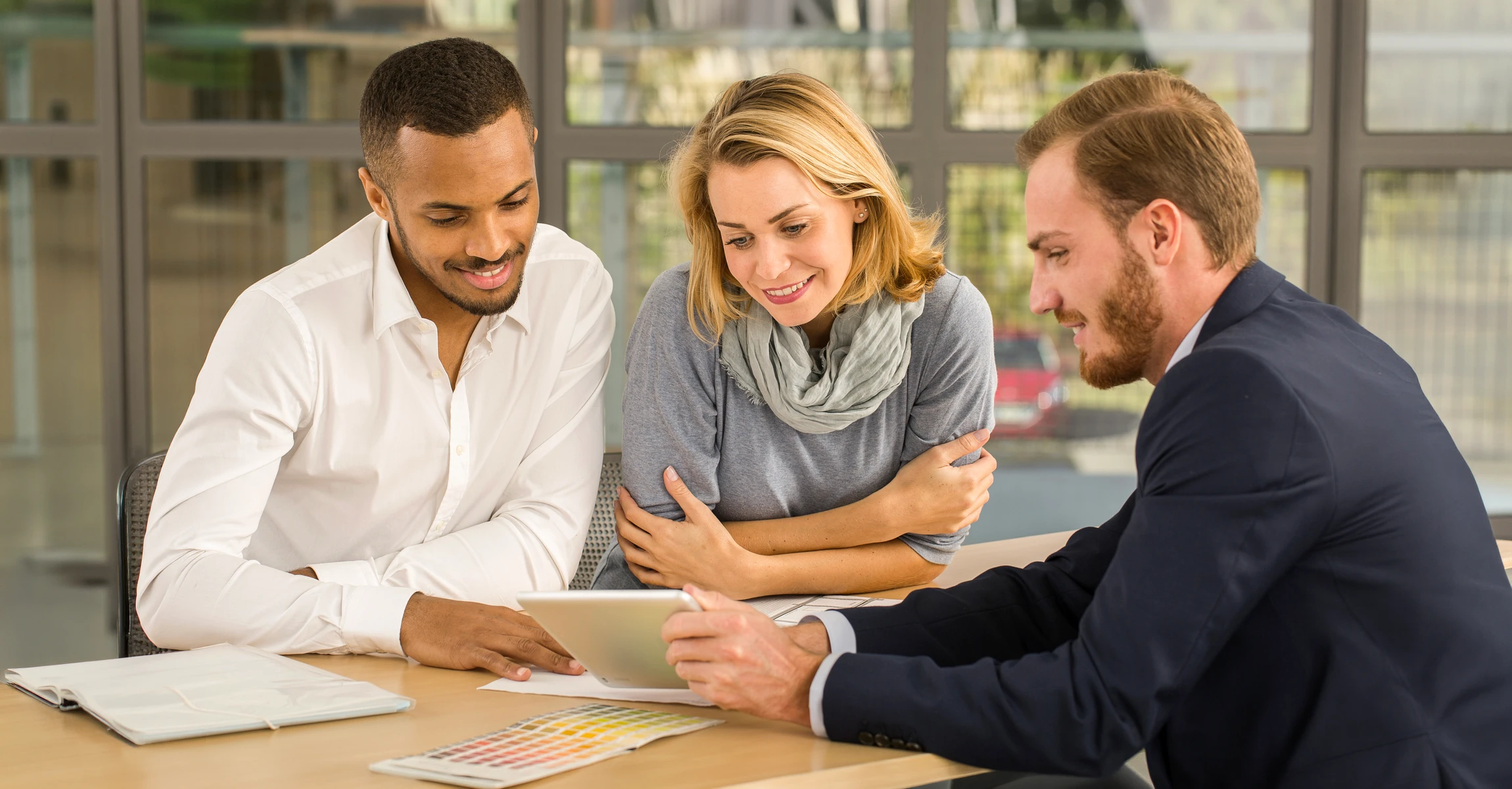 Homme d'affaires mature aux cheveux gris et barbe, souriant, vêtu d'une chemise bleue claire dans un bureau moderne